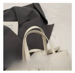 Détail de la poignée du sac crème avec double couture et ferrure métallique