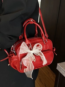 Glossy red Boston handbag with pearl bow charm and shoulder strap for women