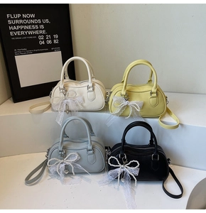 Detail view of four Boston handbags in different colors with pearl bow charms