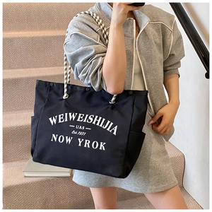 Détail du grand sac cabas en toile noire avec lettrage blanc et anses en corde souple