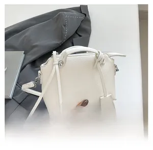 Detailansicht der weißen Handtasche mit Litschi-Lederstruktur und Silberbeschlägen