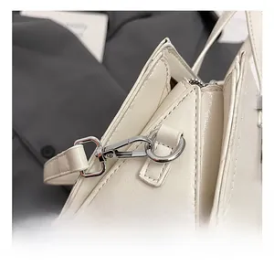 Détail du cuir huilé blanc et du crochet métallique argenté sur le côté du sac à main
