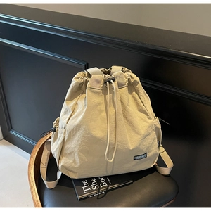 Détail de la fermeture à cordon et du logo de montagne sur le sac à dos en nylon beige