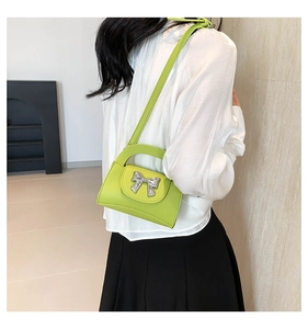 Fluorescent green mini crossbody bag with silver bow accent and adjustable shoulder strap