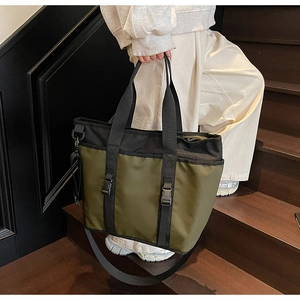 Detail of olive green oxford cloth tote bag with black straps and adjustable buckles