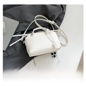 Detail der weißen Handtasche aus PU-Leder mit Metallniete und verstellbarem Riemen