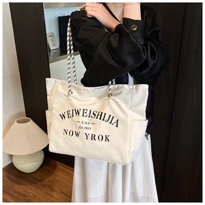 Détail du sac fourre-tout en toile blanche avec anses en corde et imprimé graphique