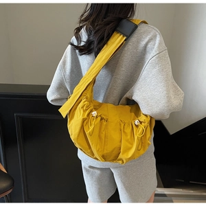 Détail du sac fourre-tout en nylon plissé jaune gingembre avec bandoulière réglable