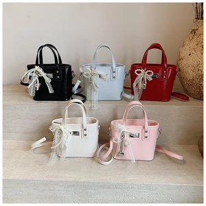 Detail showing five mini crossbody bucket bags with lace and pearl bow charms
