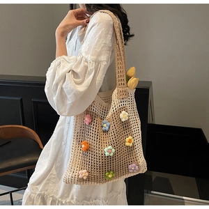 Détail du sac cabas fait main en tricot avec des fleurs en crochet 3D colorées