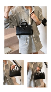 Détail du sac carré en cuir noir minimaliste avec boucle métallique et finitions argentées