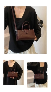 Détail du sac à main bordeaux en cuir brillant avec boucles argentées et bandoulière