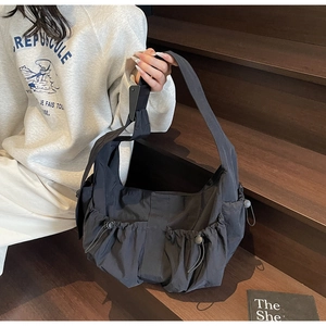 Vue latérale du sac fourre-tout noir en nylon avec poches à cordon sur l'escalier