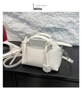 Nahaufnahme der weißen Handtasche aus Leder mit Litschistruktur und Silbernietendetails