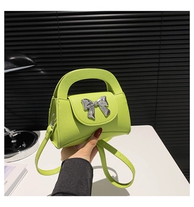 Neon green litchi leather mini bag with silver metal bow and detachable crossbody strap