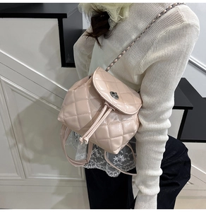 Detail view of pink quilted leather backpack with silver chain strap and metal clasp