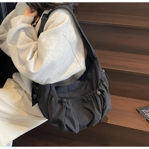 Détail du cordon de serrage et du tissu en nylon plissé léger sur le sac fourre-tout noir