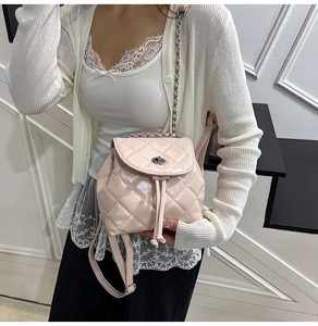 Detail of pink quilted mini backpack featuring metallic chain straps and silver twist lock
