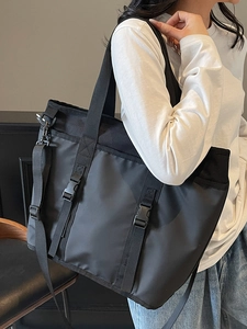 Black waterproof nylon tote bag with utility buckle straps and adjustable shoulder strap