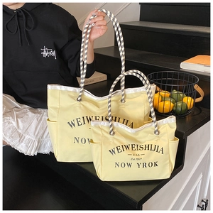 Détail de l'ensemble de sacs cabas jaunes en toile avec imprimé et anses en corde damier