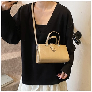 Détail d'un sac à main beige en similicuir avec poignées épurées et bandoulière réglable