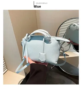Detail einer hellblauen Handtasche aus Kieselleder mit Nieten und seitlichen Lederfransen