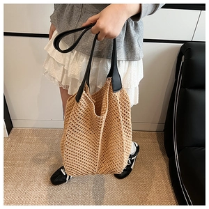 Detail of handwoven hollow tote bag showing texture and durable black faux leather handles