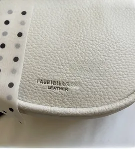 Gros plan sur la texture en cuir litchi beige de qualité avec foulard en soie chic