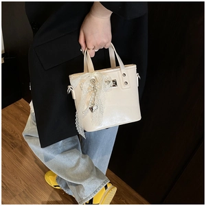 Detailed view of cream PU leather mini tote bag with lace bow and pearl heart charm