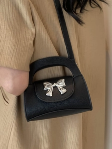 Chic black lychee leather crossbody bag with silver bow accent and top handle