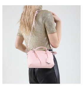 Detailansicht der rosa Handtasche aus Litschi-Leder mit Fransen an einem Model