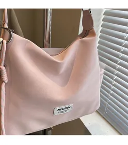 Detail showing pink textured PU leather tote bag with brand label and decorative side rope