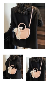 Détail du sac seau rose en cuir litchi avec poignée anneau et détail foulard à pois