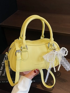 Chic lemon yellow Boston bag in pebble leather with pearl lace bow detail and shoulder strap