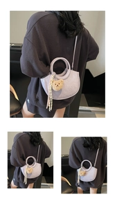 Detail of light purple leather bucket bag with cute bear charm and woven tassel detail