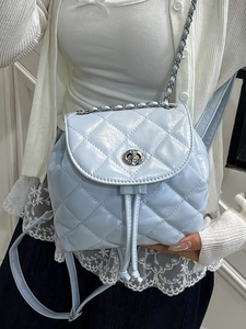 Light blue quilted leather backpack with metal chain straps and classic turn-lock closure