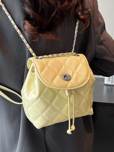 Pale yellow quilted leather mini backpack featuring silver twist lock and chain straps