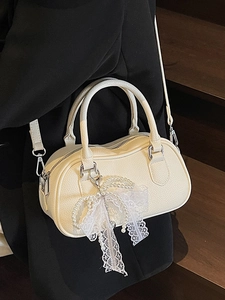 Elegant off-white Boston handbag with pearl lace bow and adjustable shoulder strap