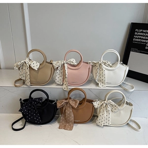 Vue détaillée des sacs seaux en cuir minimalistes en six couleurs sur plateau en marbre