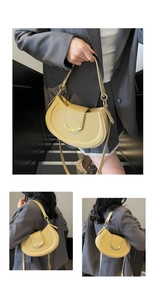 Detailed macro view of yellow lychee pattern leather saddle bag with golden metal buckle