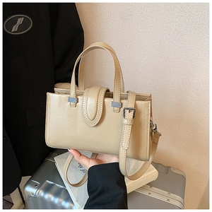 Détail du sac à main en cuir beige avec ferrures argentées pour les trajets professionnels