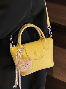 Sac à main jaune vif avec texture litchi, pendentif ours et bandoulière amovible