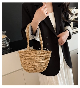 Close-up of woven straw handbag featuring a drawstring lining and sturdy round handles