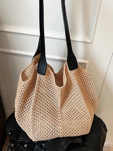 Minimalist woven hollow tote bag in beige with black leather straps on a dark background