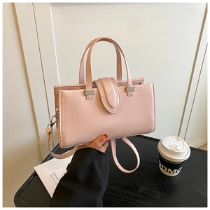 Gros plan du sac à main rose avec fermoir argenté et bandoulière amovible