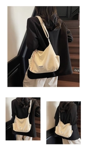 Detail of beige canvas tote bag with side pocket and woven knot charm accessory