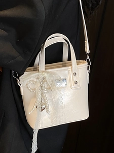 Elegant cream leather bucket bag with lace bow and pearl charm for women's crossbody wear