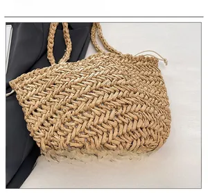 Close-up detail of the tight herringbone weave pattern on the brown straw shoulder bag