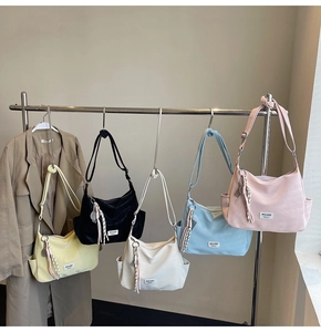 Detailed row of candy-colored tote bags in yellow, black, white, blue, and pink hanging on hooks