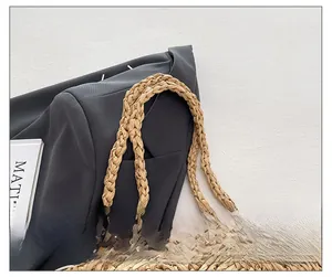 Detailed macro view of handcrafted straw tote bag with braided handle and natural texture